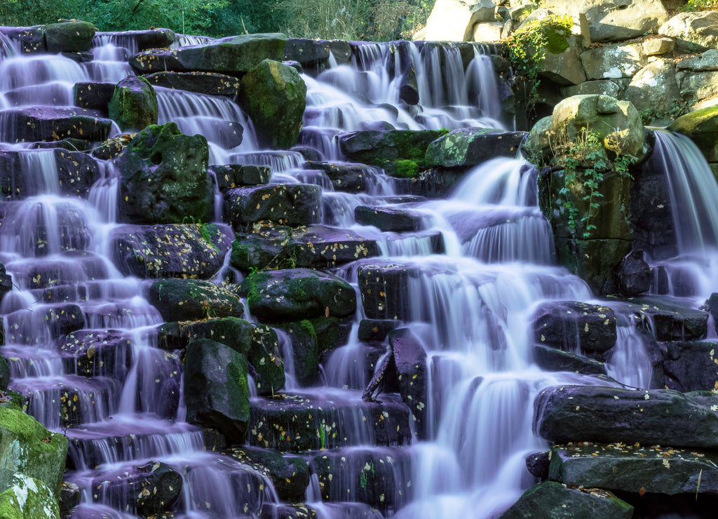 The ornamental Cascade waterfall with purple water in Virginia Water, Surrey, UK