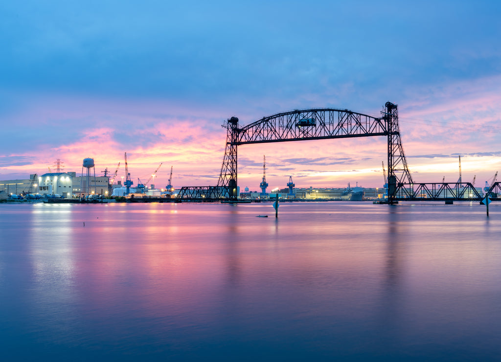 Vertical lift bridge for railroad over the Elizabeth River on the border of Norfolk and Chesapeake Virginia against a beautiful red, purple, pink, and blue sunset