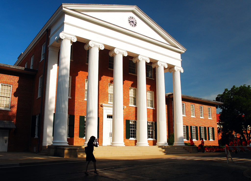 A young woman walks in front of the Lyceum on the campus of the University of Mississippi in Oxford