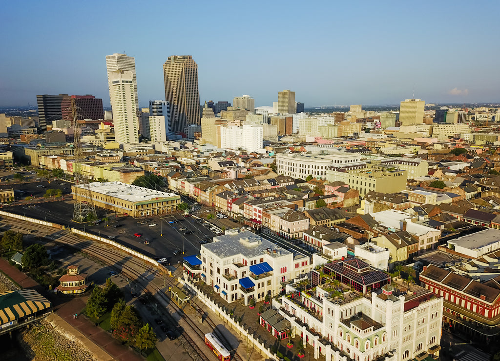 Aerial view Central Business District (CBD), a Mississippi riverside downtown of New Orleans at sunrise. Preserved 19th century French Quarter building in front of skyscrapers and modern office towers