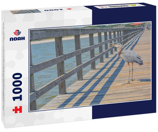 A Great Blue Heron eats a fish on the fishing pier at Gulf Port, Harrison County Mississippi, Gulf of Mexico USA