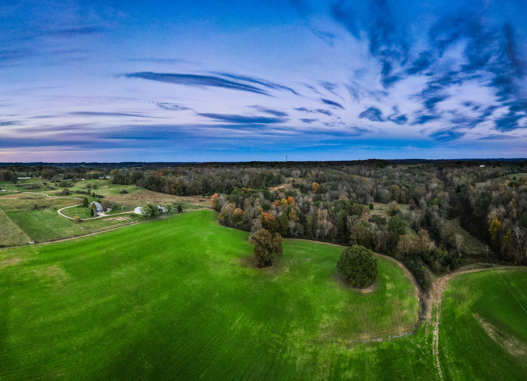 Bright green meadow around Glasgow, Kentucky with colorful sky sunset