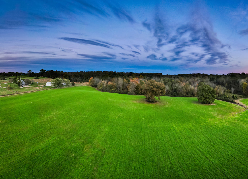 Bright green meadow around Glasgow, Kentucky with colorful sky sunset