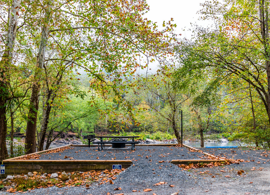 Empty permit required campground site for disabled people with car spot and river, picnic table, fire pit in Grandview Sandbar West Virginia