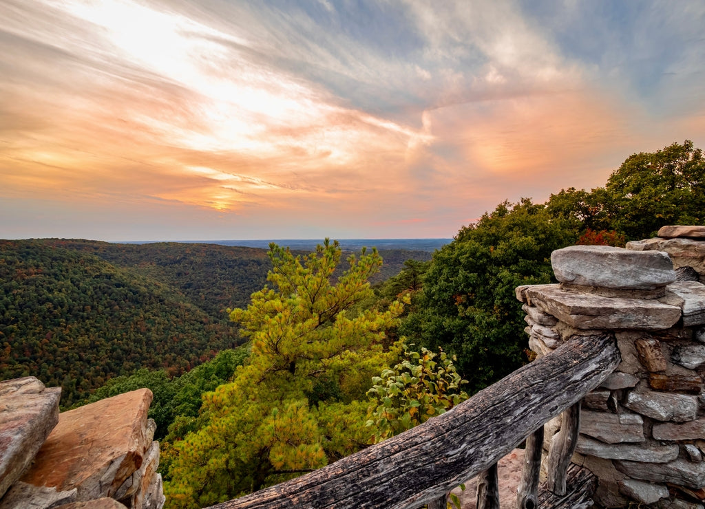 Coopers Rock State Forest in West Virginia in the Fall at Sunset with the sky filled with orange and blue, and the mountains and trees in the distance. Beautiful scenic nature