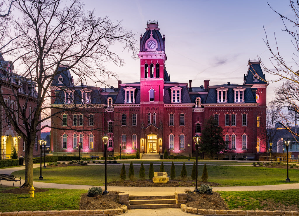 Dramatic image of Woodburn Hall at West Virginia University or WVU in Morgantown West Virginia as the sun sets behind the illuminated historic building