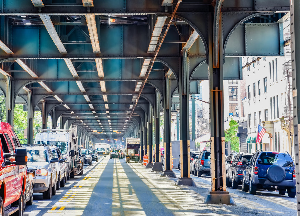 Bottom view of Elevated train track nyc. Traffic waiting in road in a sunny day. Travel and traffic concepts. Bronx, New York, USA