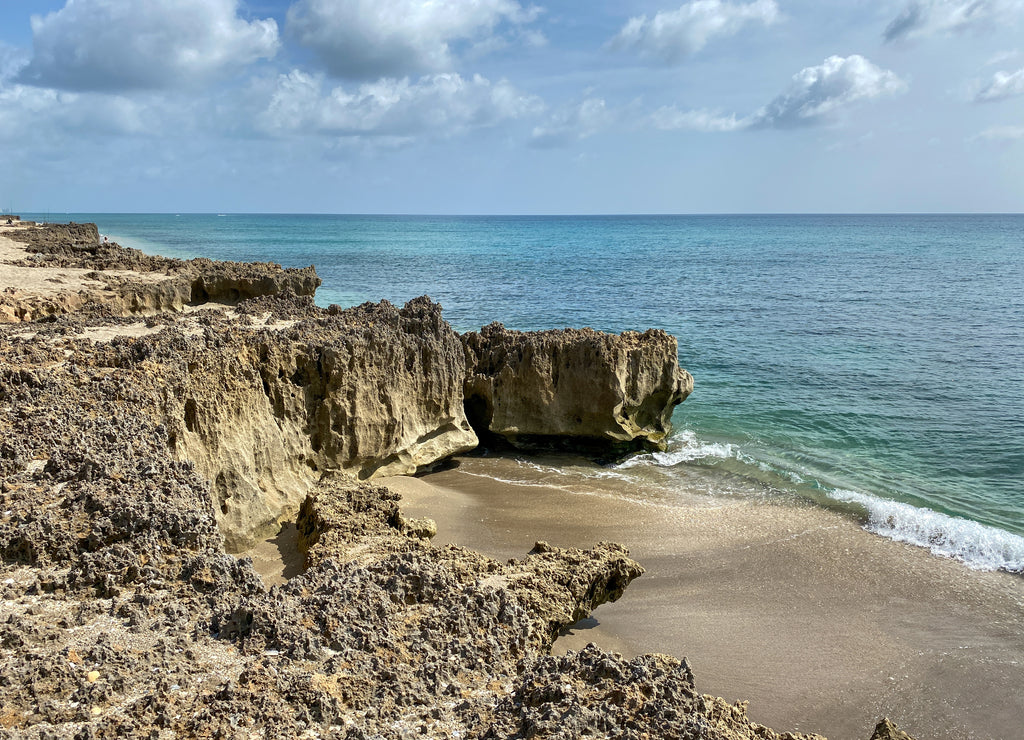 A rocky beach with clear turquoise water in Stuart, Florida
