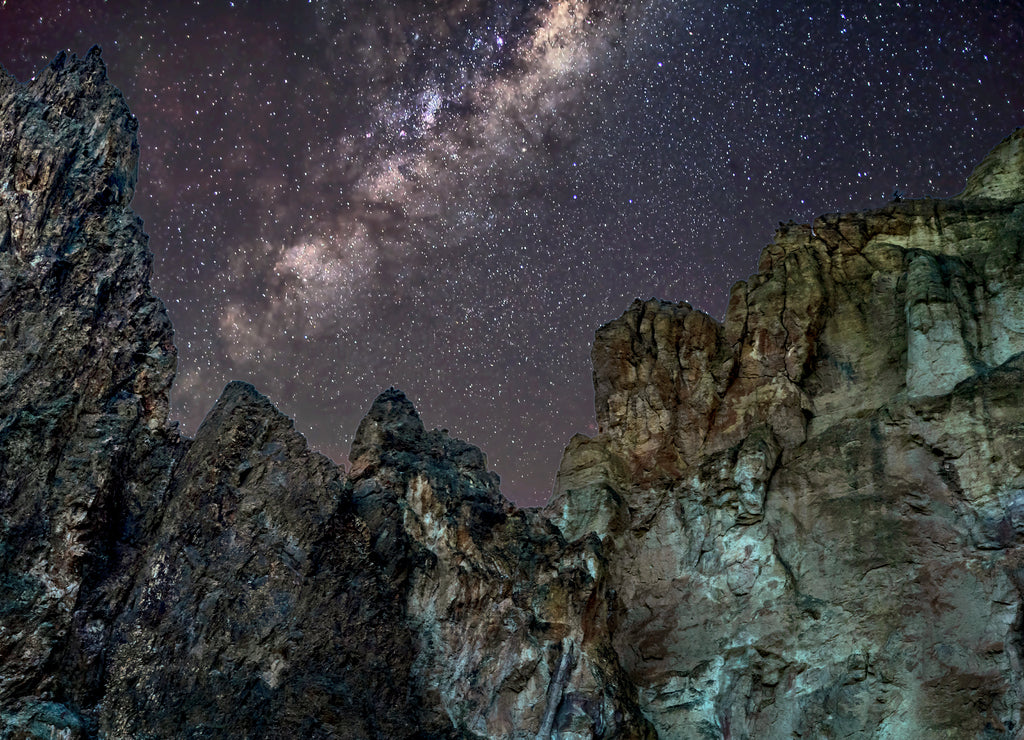 The towering cliffs under a star filled night sky at Smith Rock State Park near Bend, Oregon, USA at night time