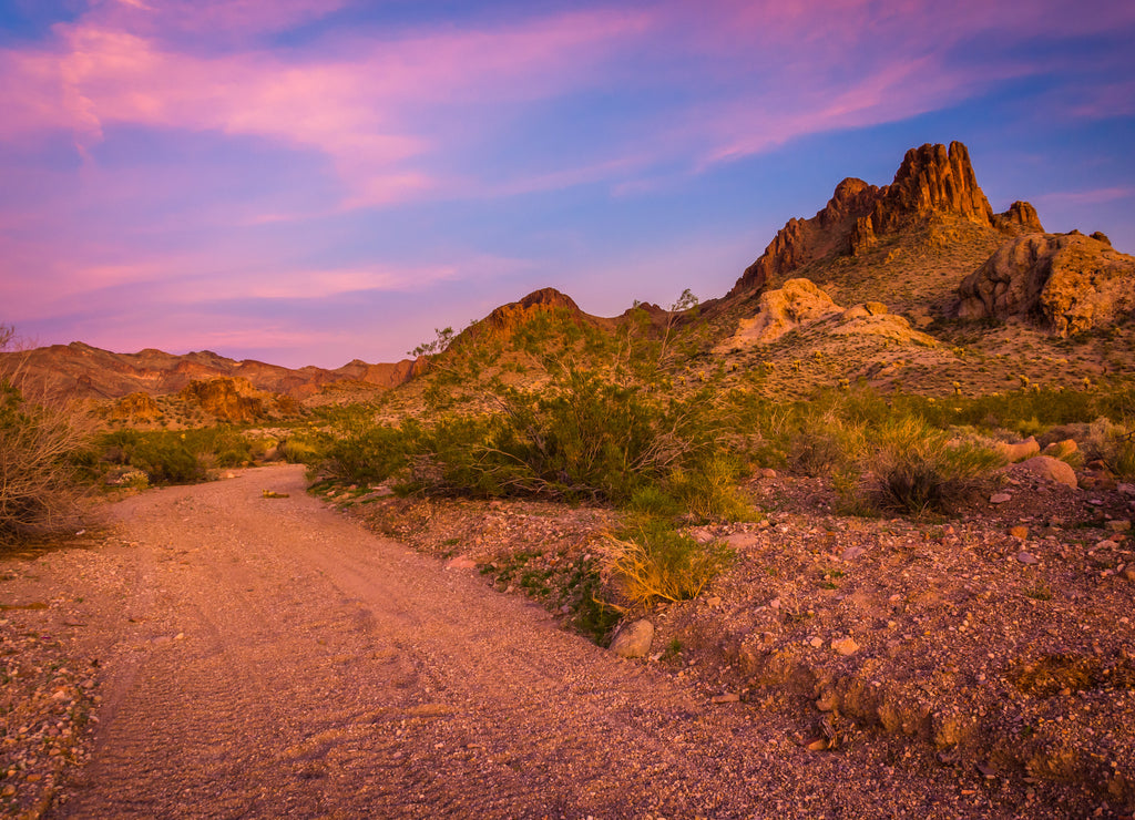Dirt road and mountains in the desert at sunset near Oatman, Arizona