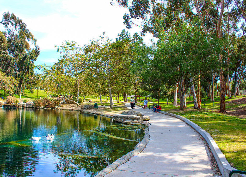 people walking on a pathway in the park next to the lake at Kenneth Hahn Park in Los Angeles California
