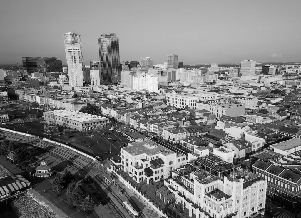 Aerial view Central Business District (CBD), a Mississippi riverside downtown of New Orleans at sunrise. Preserved 19th century French Quarter building in front of skyscrapers and modern office towers in black white