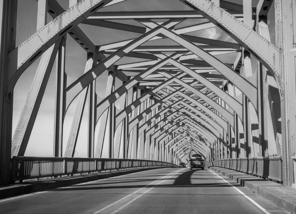 Driving on the Conde B. McCullough Memorial Bridge, Oregon, formerly the Coos Bay Bridge, on a sunny day in black white