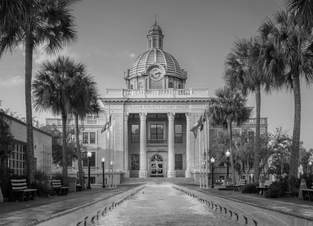 Historic Volusia County Courthouse with copper dome from fountain pool in DeLand, Florida in black white