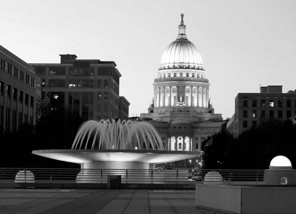 Wisconsin State Capitol building. National Historic Landmark. Madison, Wisconsin, USA. Twilight scene with illuminated fountain in the foreground. Vertical view from Monona terrace balcony in black white