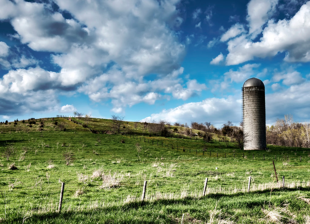 Hillside pasture against cloudy sky in Madison County, rural Iowa USA