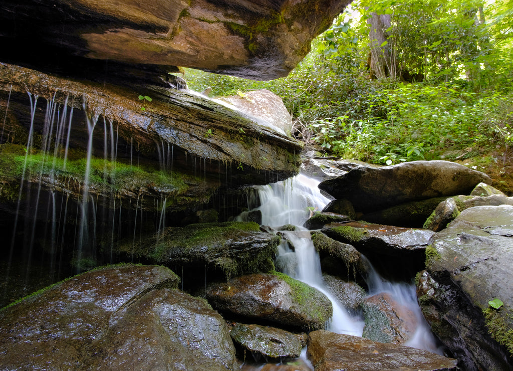 Silky water flowing over rocks and moss at Otter Falls trail in Seven Devils, North Carolina, USA, near Banner Elk