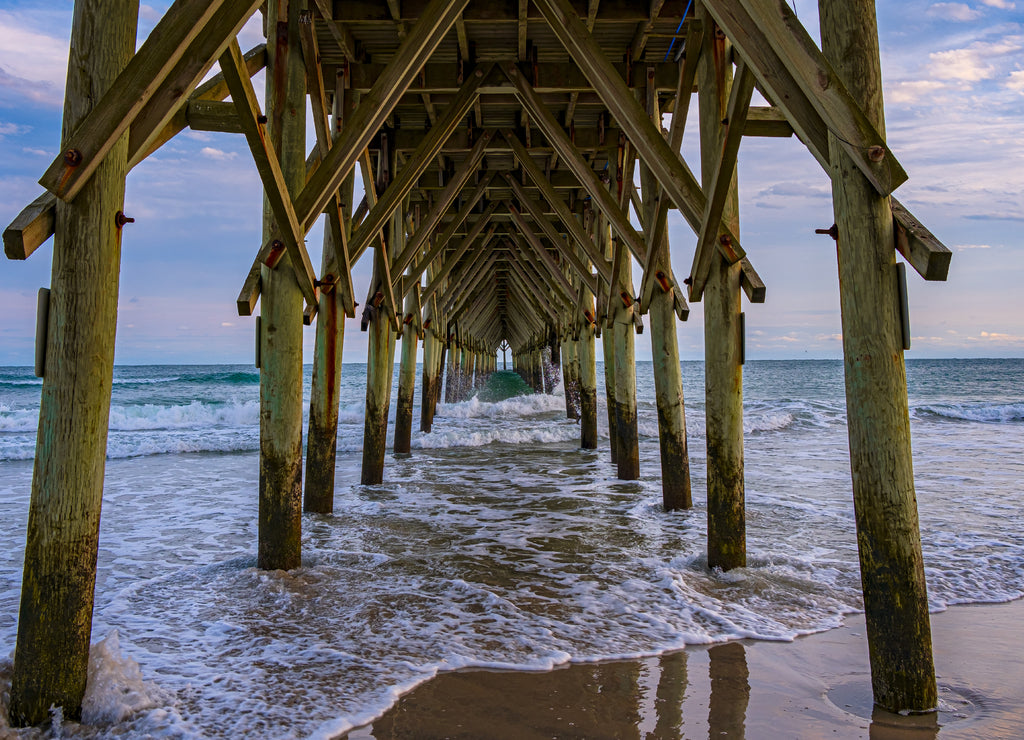 Beautiful view under a wooden pier on a water beach on the coast of North Carolina