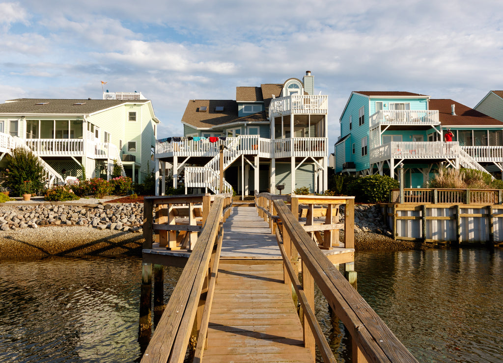 Long wooden dock leading to three luxury vacation rental beach houses on the intercoastal waterway, Sunset Beach, North Carolina